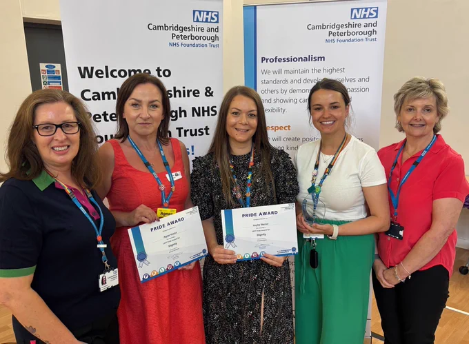 Five individuals holding Pride Awards stand in front of a banner reading "Welcome to Cambridgeshire & Peterborough NHS Foundation Trust."