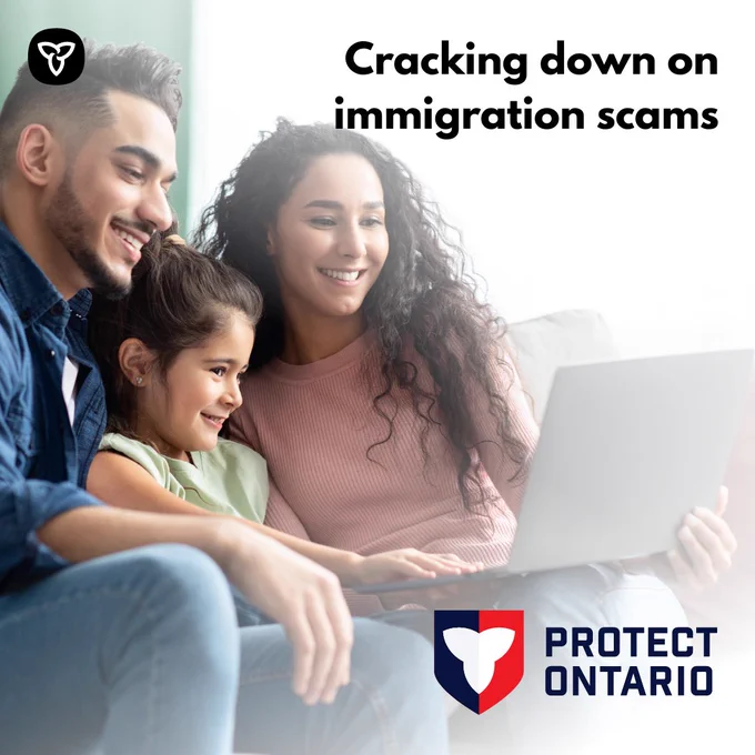 A smiling family crowd around a laptop