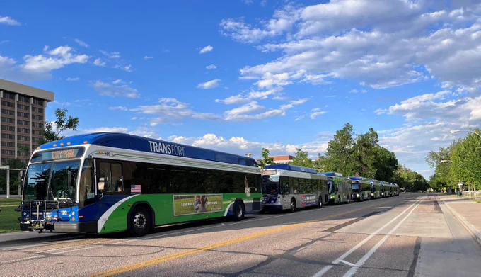Several buses lined up on a street. 