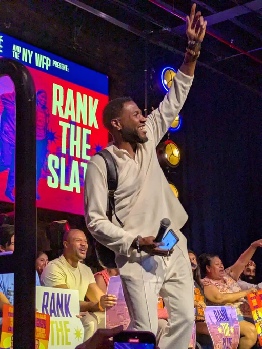 Photo of Jumaane Williams speaking at a rally in front of a screen that says: rank the slate.