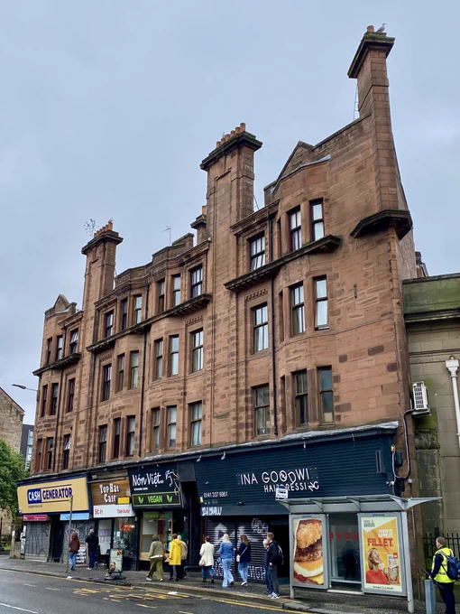 This is a rather good mixed use Glasgow Baroque tenement of 1910-12 at 271-285 Dumbarton Road in Glasgow. With its ground floor shops and red sandstone upper storeys, the tenement is by accomplished architects Campbell Douglas and Alexander Nisbet Paterson. The combination of a strong cornice line with soaring chimney stacks, especially the canted one to the west, breaking through it, is superb.