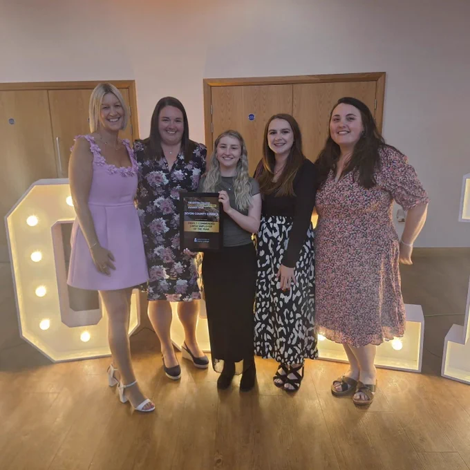 Picture of the Devon County Council representatives all dressed up for the evening, with the person in the centre holding the award.