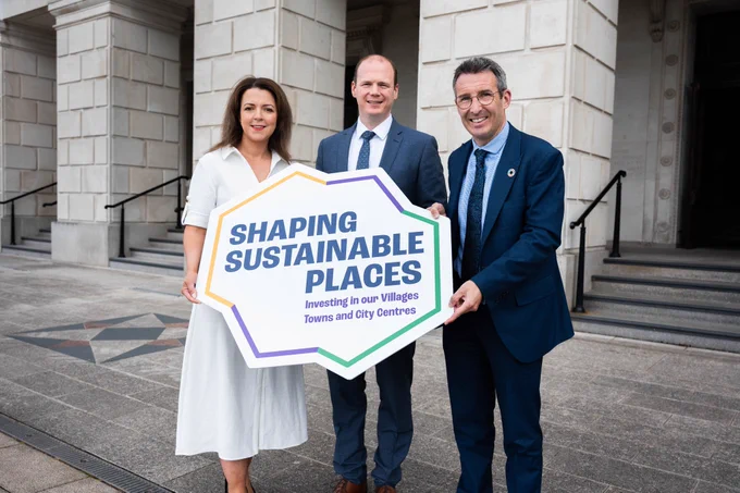 Group photo with Minister Kimmins (L), Minister Lyons (M) and Minister Muir (R), holding the Shaping Sustainable Places sign, outside of Stormont.