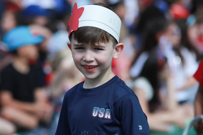 A Jaworek School student wears a white cardboard crown with a red star and a navy blue shirt that says 'USA' on the left-hand side.