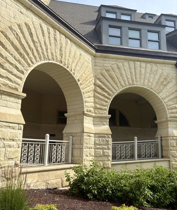 Exterior view of Hale Library with arched stone entryways and decorative metal railings.