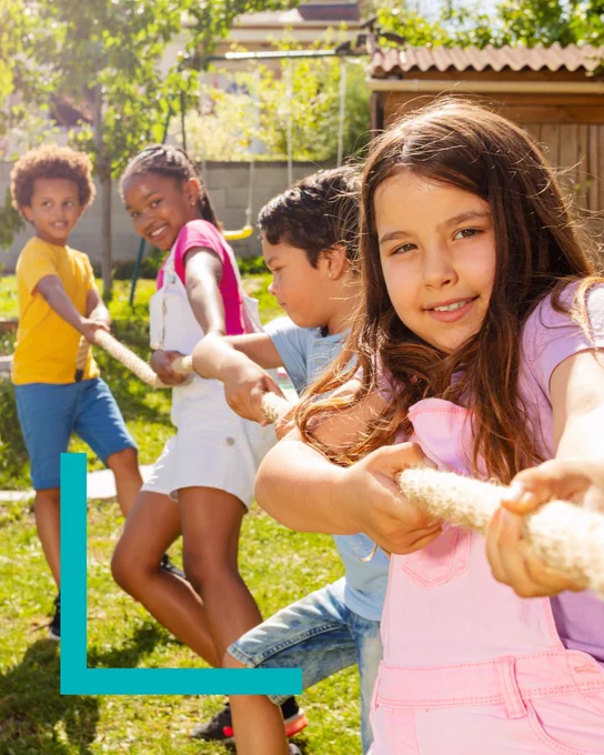 Four children play tug-of-war in a sunny backyard. Each is pulling a rope, smiling and determined. The scene is lively and cheerful.