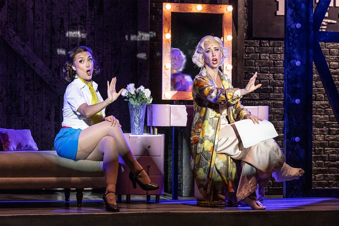 Two actresses on a Broadway dressing room set on stage.