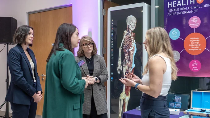 4 people talking in front of a screen showing a 3D skeleton