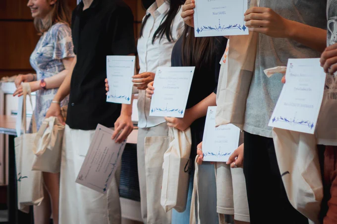 Photo des diplômes tenus par les lauréats des Olympiades de mathématiques.