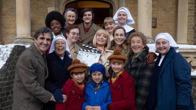 The cast of Call The Midwife gather on the steps of Nonnatus House with a clapperboard signalling the start of filming.