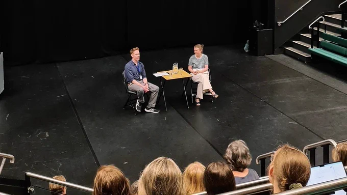 Director Amy Leach sits talking to Mark Love-Smith on a large auditorium stage at The University of York 