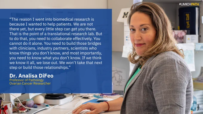 Portrait of Dr. Analisa DiFeo, Professor of Pathology and ovarian cancer researcher at the University of Michigan, standing at her lab bench. A quote from her is featured on the left: “The reason I went into biomedical research is because I wanted to help patients... You cannot do it alone... If we think we know it all, we lose out. We won’t take that next step or build those relationships.” The image is branded with the hashtag #UMICHPATH.