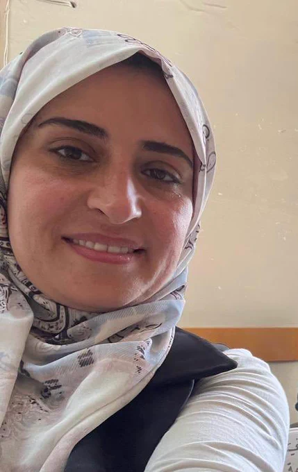 A photograph of Tahani a beautiful female wearing a hijab looking at the camera smiling