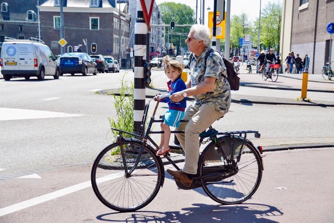 People of all ages and abilities use a variety of two- and three-wheeled mobility devices to travel on dedicated cycling infrastructure in Dutch cities.