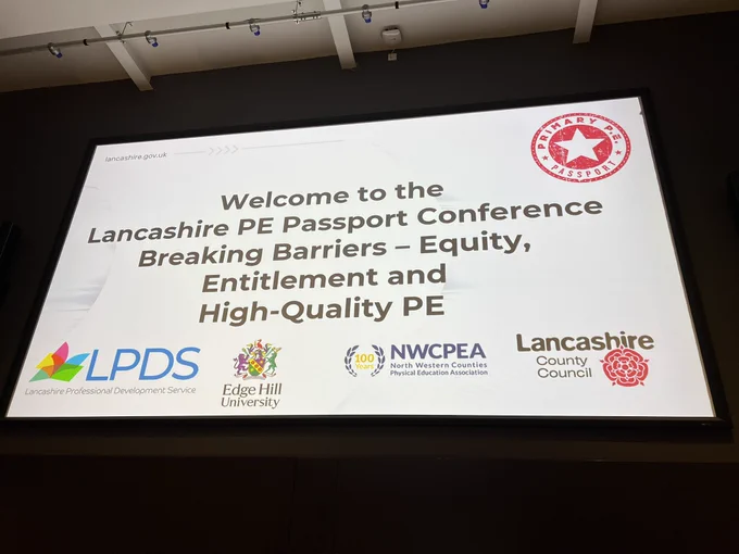 A photo of a holding slide with the conference title “Welcome to the Lancashire PE Passport Conference: Breaking Barriers - Equity, Entitlement and High-Quality PE.”