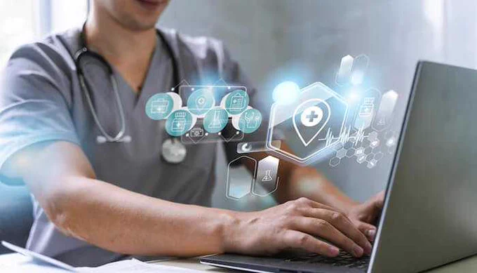 A healthcare professional using a laptop with digital icons representing medical services, data, and Health Benefit Plans for patient care management.