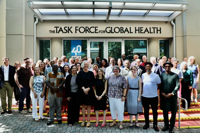 A large group of global health professionals pose together on the steps outside The Task Force for Global Health building, smiling and waving at the camera during the 33rd Trachoma Expert Committee meeting. The building signage and a "40" anniversary logo are visible in the background.

Photo credit: Sumon Ray.