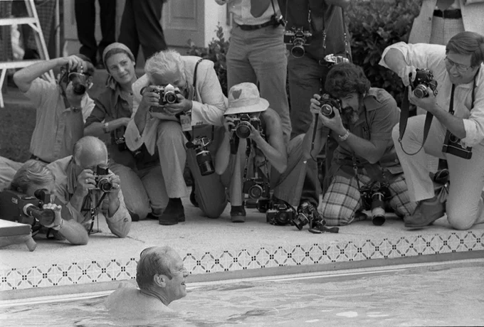 President Ford’s head pokes above the water as poolside photographers lean down for photos.