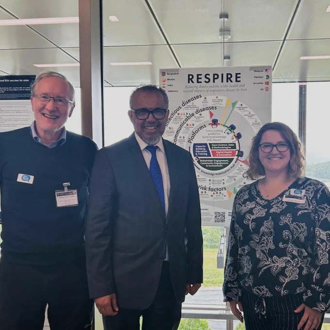 Harry Campbell, Tedros Adhanom Ghebreyesus and Dominique Balharry smiling beside a RESPIRE poster. 