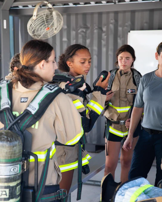 girls on fire campers looking at equipment.