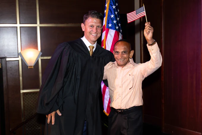 Photo courtesy of MO Boys State. Judge Schelp and a new citizen holding an American flag. 