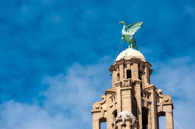 A sunny day with blue sky behind and the Liver Bird on top of the Royal Liver Building in the City of Liverpool in the foreground