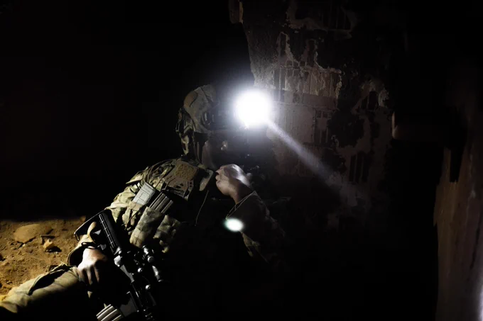 U.S. soldier communicates via radio in a tunnel system with opposition forces located inside.
