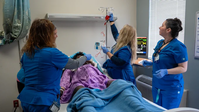 Three individuals participate in simulation training