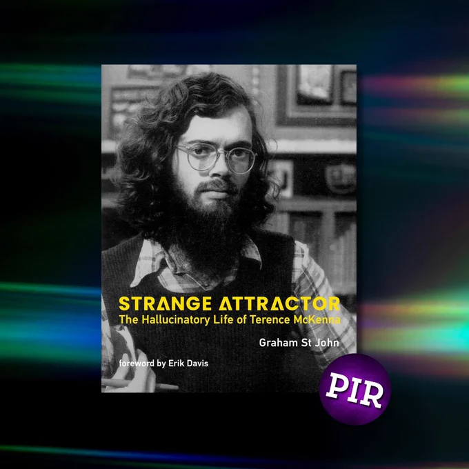 Black-and-white book cover featuring a young Terence McKenna with long curly hair, a beard, glasses, and a plaid shirt under a sweater vest. The title reads “Strange Attractor: The Hallucinatory Life of Terence McKenna” by Graham St John, with a foreword by Erik Davis. A purple circular sticker with “PIR” is in the bottom-right corner.
