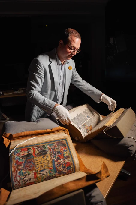 Dr Harry Spillane, Munby Fellow, Cambridge University Library, consulting the two Bibles © Angharad Bache / National Library of Wales