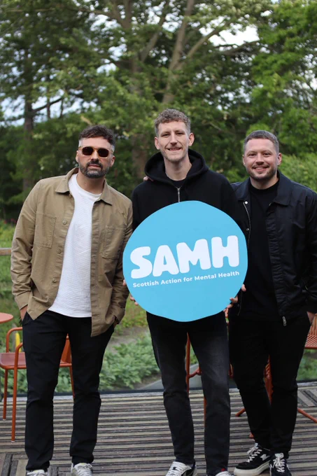 Nathan Evans and Saint PHNX band hold a SAMH logo