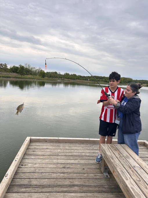 students and staff fishing and showing photos of their fish