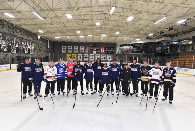 Photo of group of people posing for a photo on ice, including James Hagens, Porter Martone, Simon Wang, Jake O'Brien, Michael Misa and Matthew Schaefer