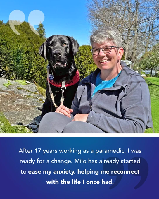 A smiling person sits on the grass in a park beside their black Labrador Service Dog, Milo, who is wearing a red vest labeled “Guide Dogs.” The background features green hedges and a clear blue sky. At the bottom of the image, a testimonial reads: “After 17 years working as a paramedic, I was ready for a change. Milo has already started to ease my anxiety, helping me reconnect with the life I once had.”