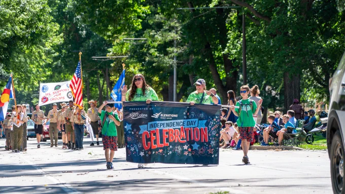 Kids carry an Independence Day Celebration sign in a parade