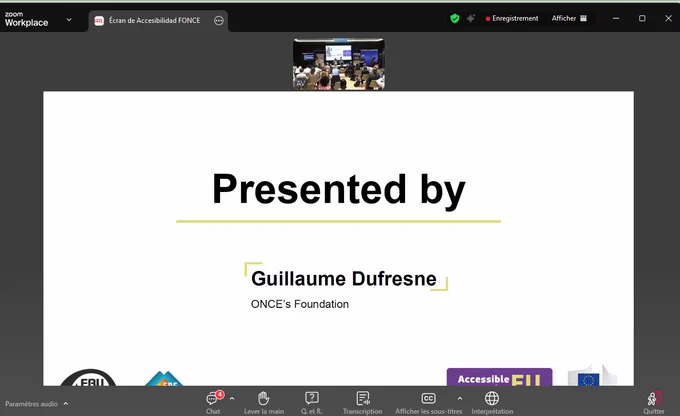 A Zoom presentation of a hybrid event. On top, there is a physical room displaying the people attending the event in-person. Below, there is a screen displaying the text "Presented by Guillaume Dufresne". 