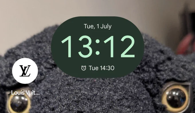 A phone screen showing 13:12 as the time on Tuesday, 1st of July. The background is a very handsome mid-sized fuzzy plushed family staring at the viewer, slowly hypnotising them. The only app on the home screen is the Louis Vuitton app.