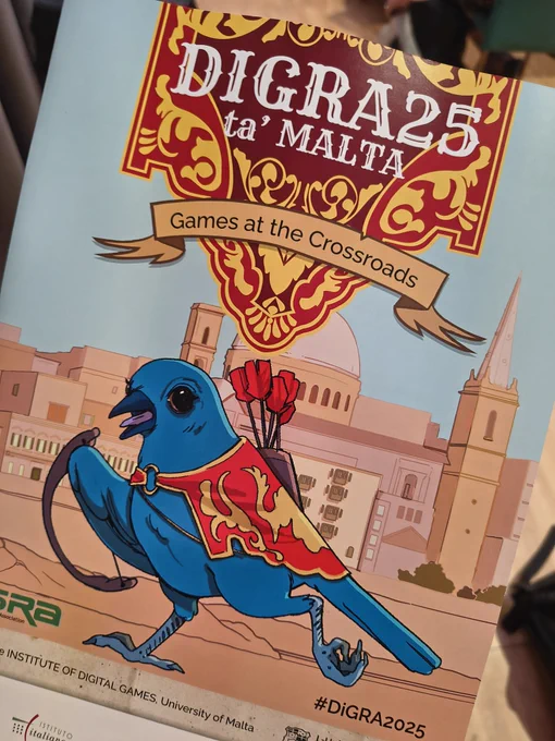 Picture of the DiGRA2025 brochure showing the blue bird mascot. 