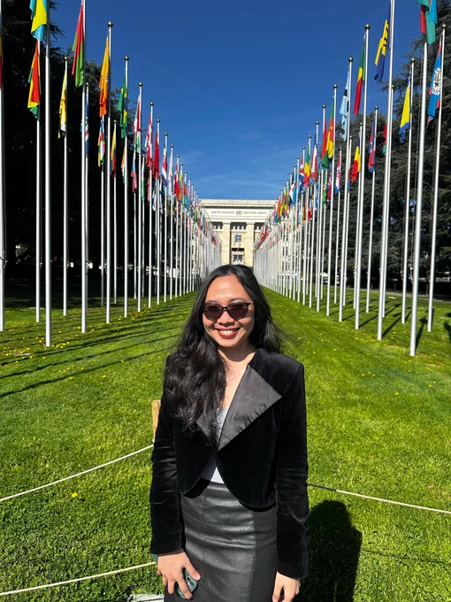 Woman standing with flags behind her.
