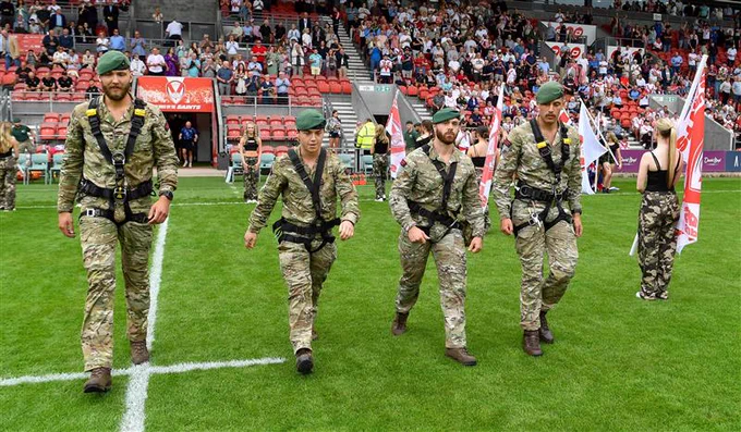 Marines walking on the pitch at Saints' Totally Wicked Stadium after abseiling as part of Armed Forces Day celebrations