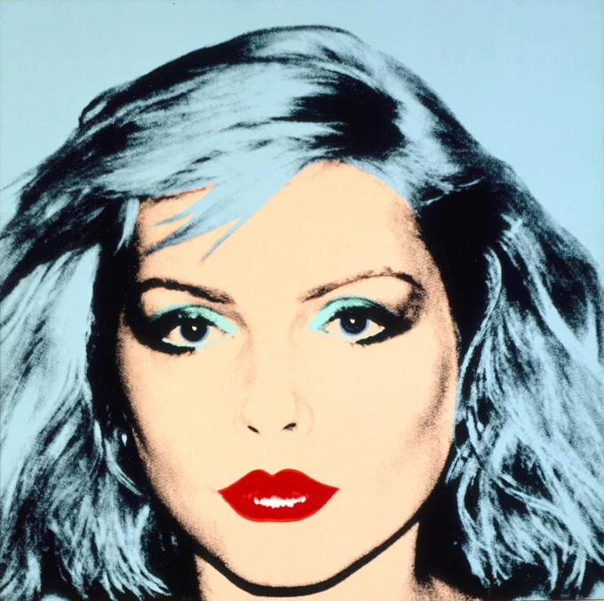 Pop Art portrait by Andy Warhol featuring Debbie Harry with vibrant blue hair and striking red lips against a blue background.