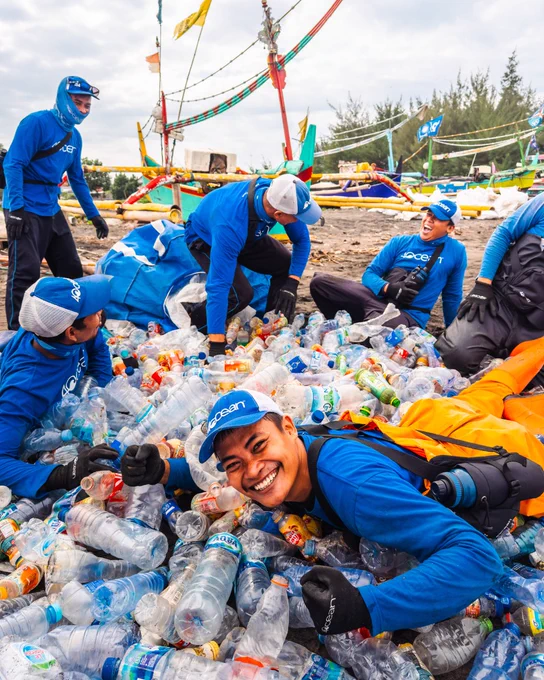 4ocean workers collecting and sorting plastic bottles on a beach for a cleanup event.