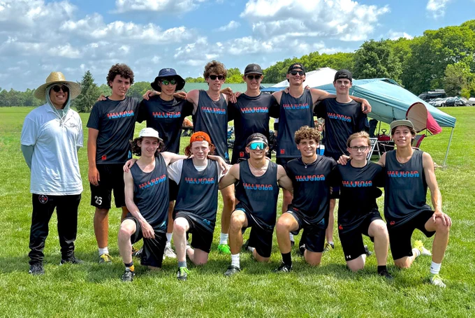 Team photo of U20 team Illinois Illusion. 12 players and a coach pose on a field in team apparel.