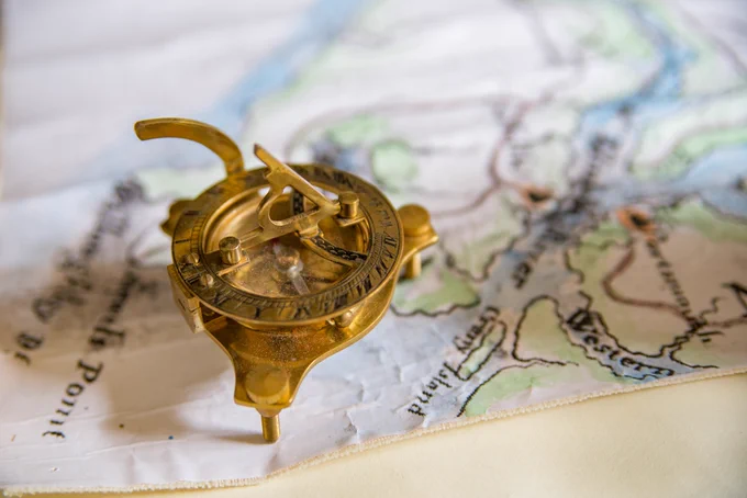A compass sitting on top of an old map.