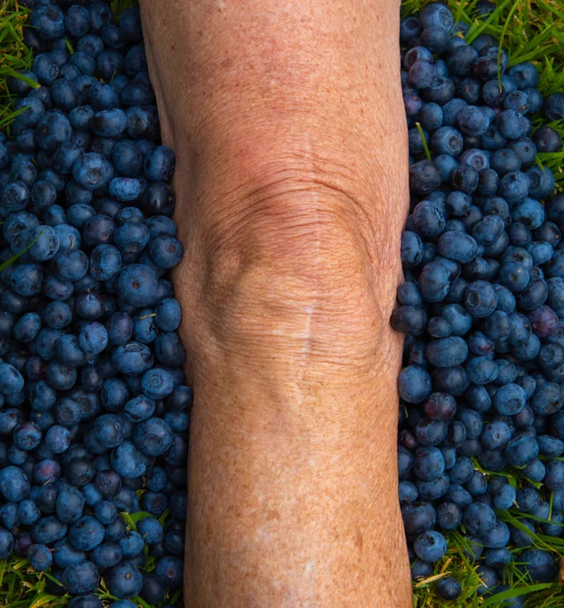 Foot treading on pile of blueberries