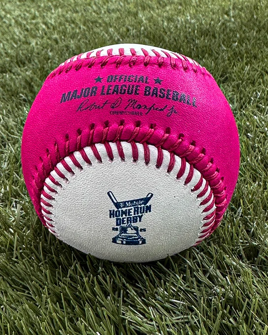 A white and magenta Rawlings baseball with red stitching and the 2025 T-Mobile Home Run Derby logo on it. 