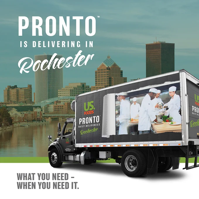 An advertisement showing a U.S. Foods delivery truck for Pronto, parked with an image of chefs on the side, set against a backdrop of Rochester's city skyline. The text reads: 'PRONTO is delivering in Rochester' and 'What you need – When you need it.'