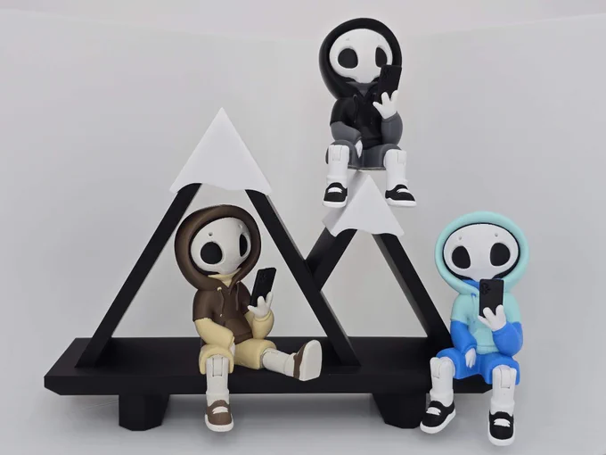 Three articulated Project Hazy figures — Shadow, Mocha, and Chill — posed on a black triangular shelf. Each wears a hoodie and holds a phone, arranged at different heights.