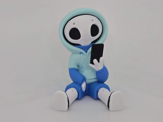 Chill Hazy figure in light mint and blue, sitting with a phone in hand against a white background.