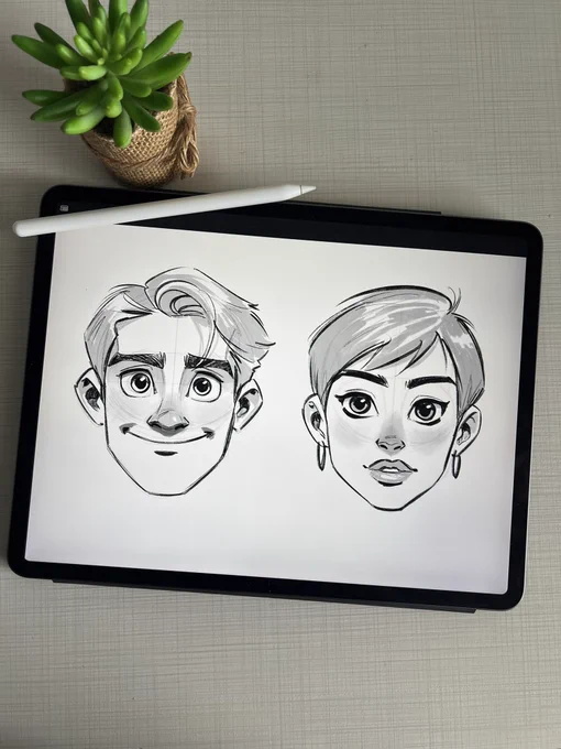 Cartoon pencil sketches of a smiling boy and a girl, drawn on an iPad.